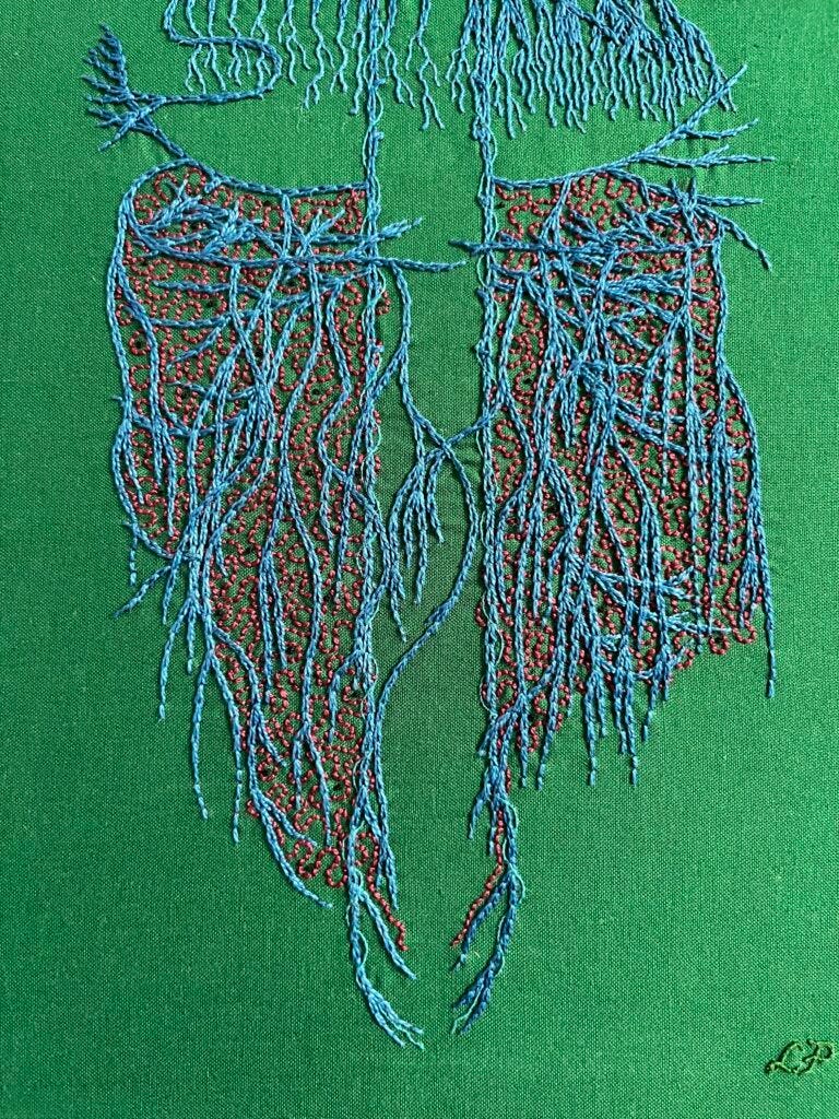 A close up of an embroidery focused on the abdominal vagus stitched in blue chain stitch in perlé thread on dark green cotton. There are many layers of crossing wavy lines. Spiralling around the very straight main vagus is single strand whipped back stitch in electric blue. Some roiling burgundy back stitch in burgundy perlé thread is between the blue. Sparse tiny black French knots are stitched in the gut area. The nerve endings in the diaphragm area are lengthened with one and two strand whipped back stitch.