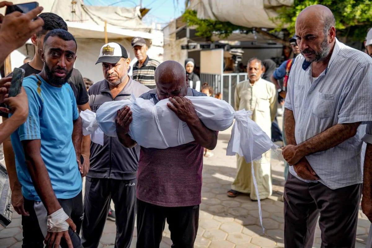 A man mourns as a victim of the airstrike is brought to hospital in Deir al-Balah (AP)