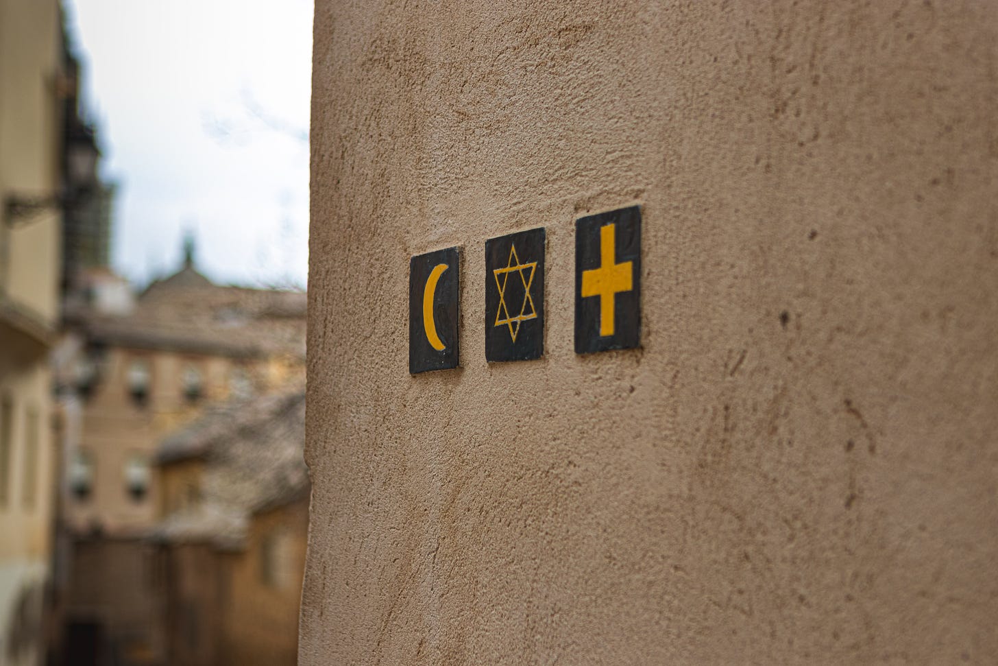 Symbols of a crescent, star and cross on a a wall.