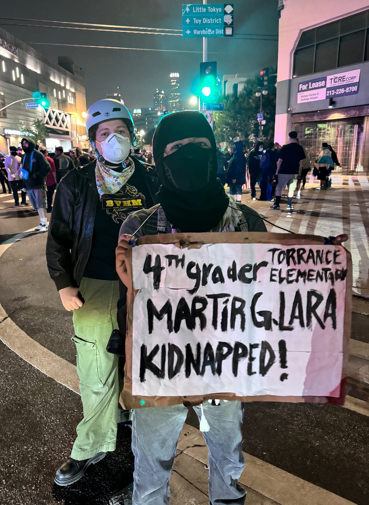Woman holding sign, masked