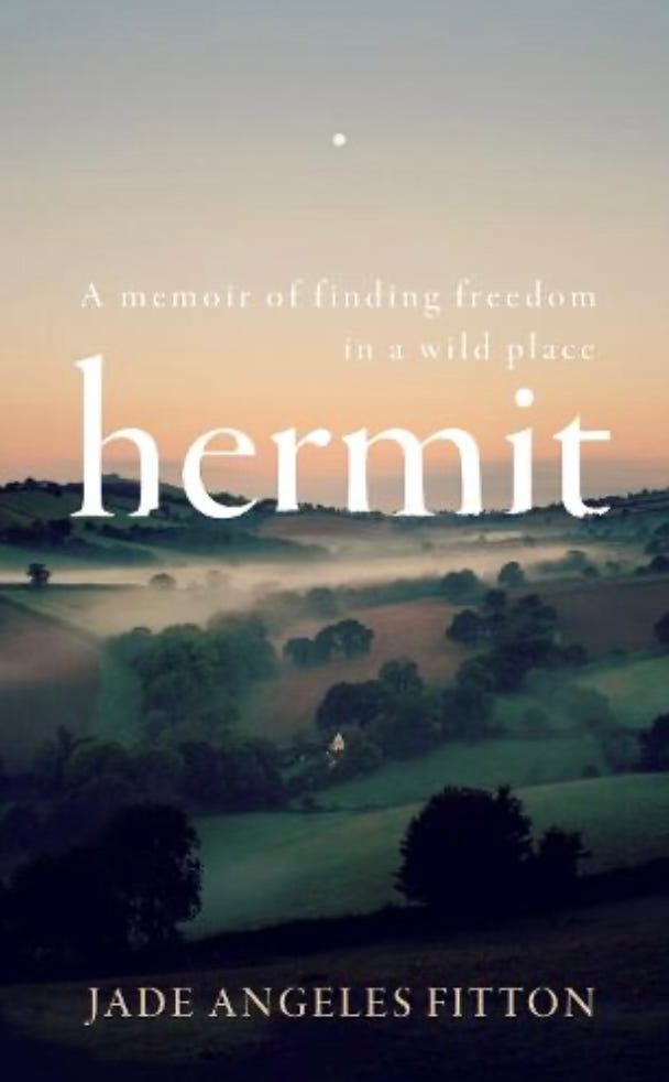 Book cover for Hermit by Jade Angeles Litton, text in white on a view across misty valley of greens with trees and fields and a soft orange sunset across the top half of the cover