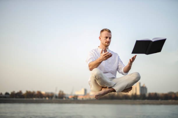 Portrait Of Young Beautiful Man Meditating In Mid Air Floating Outdoors  Above Ground Sitting With Crossed Legs In Lotus Posture Padmasana Stock  Photo - Download Image Now - iStock
