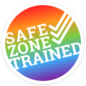 Circle graphic with soft rainbow background. Text in all caps white bold: "Safe Zone Trained" with 3 check marks on top of each other.