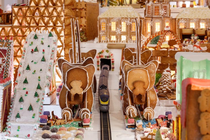 A miniature town made from gingerbread with a model train running through the middle