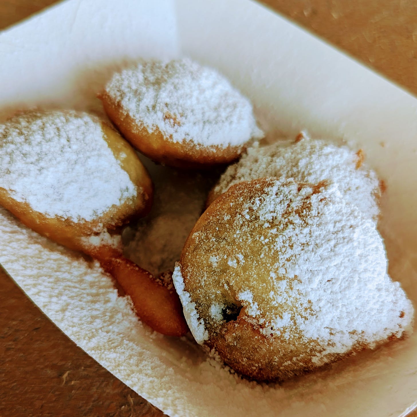 A container with fried Oreos covered in powdered sugar.