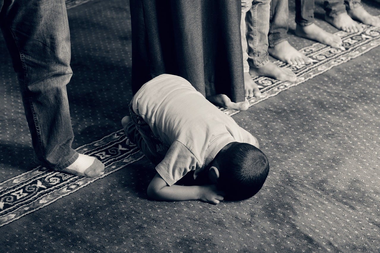 Kid praying in a mosque