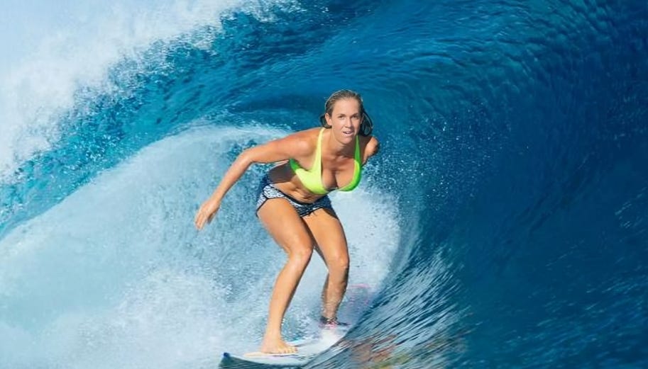 Bethany Hamilton surfing powerfully through a wave, embodying strength, resilience, and her unshakable faith in action.