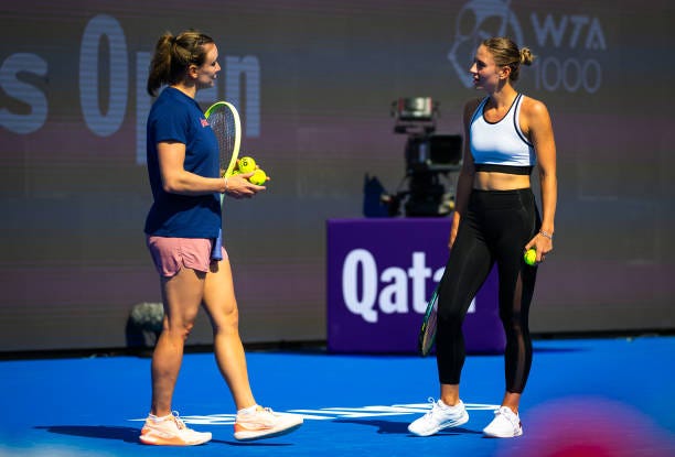 Marta Kostyuk of Ukraine talks to coach Sandra Zaniewska during practice ahead of the Qatar TotalEnergies Open, part of the Hologic WTA Tour at...