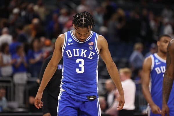 Jeremy Roach, wearing a blue Duke jersey with a No. 3 on it, lowers his head while walking off the court.