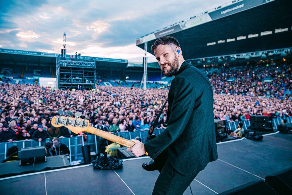 Kaiser Chiefs’ bassist, Simon Rix, facing the camera and performing in front of a huge crowd at Elland Road in 2019 Kaiser Chiefs’ bassist, Simon Rix, facing the camera and performing in front of a huge crowd at Elland Road in 2019
