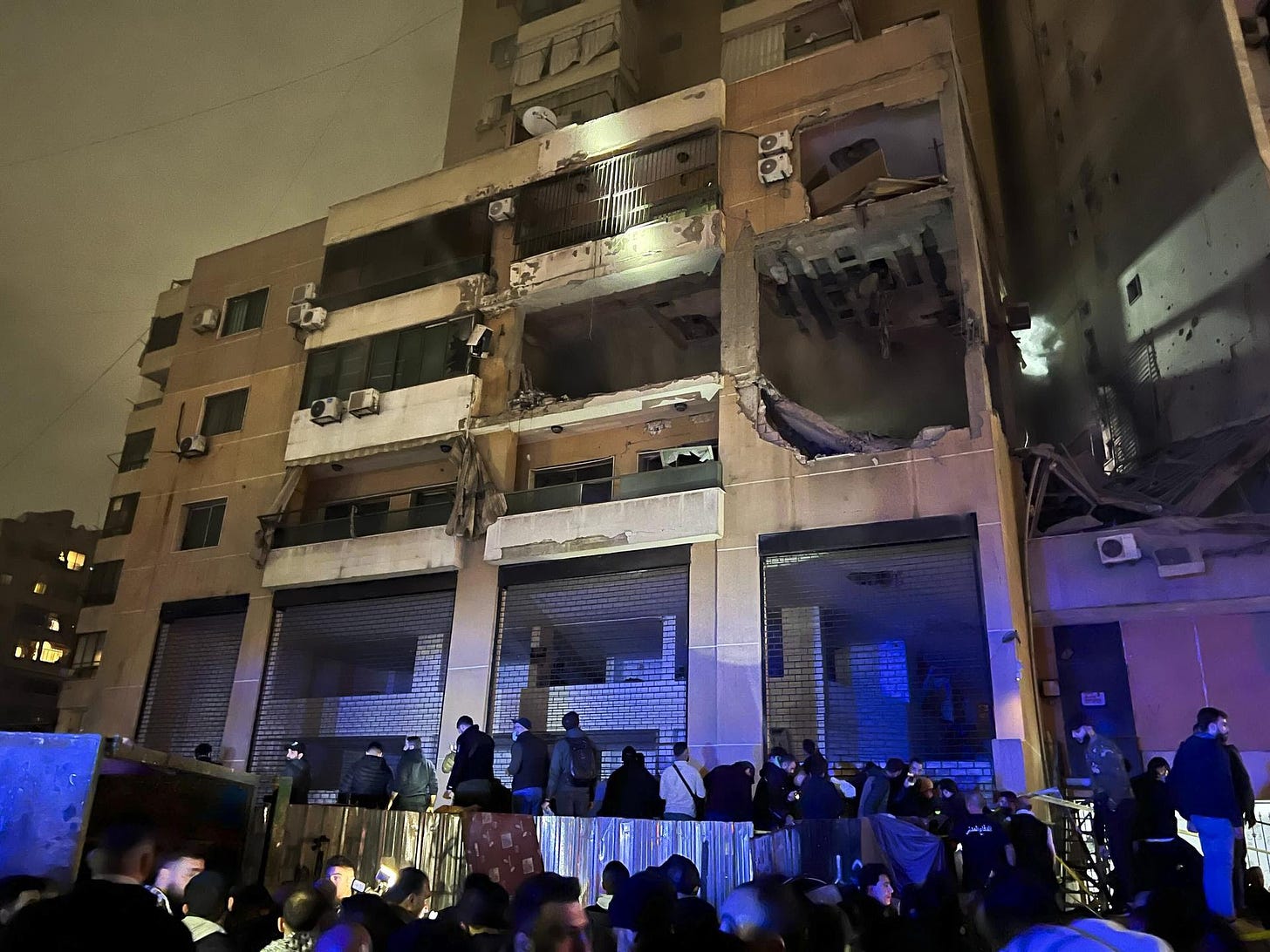 People stand outside a building after an explosion.