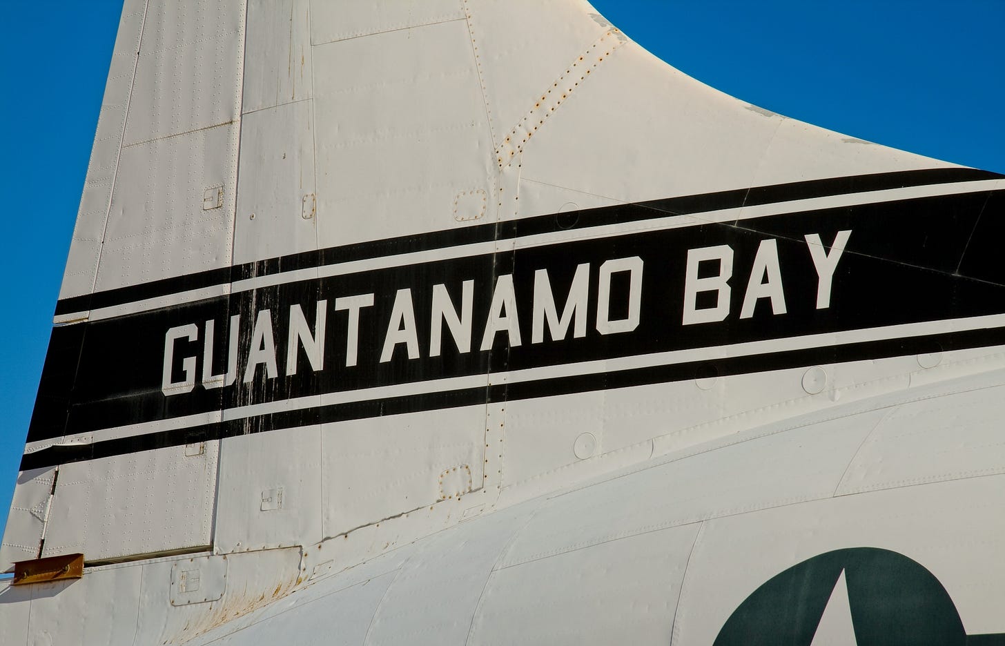 Photo of plane's tail portion with words Guantanamo Bay