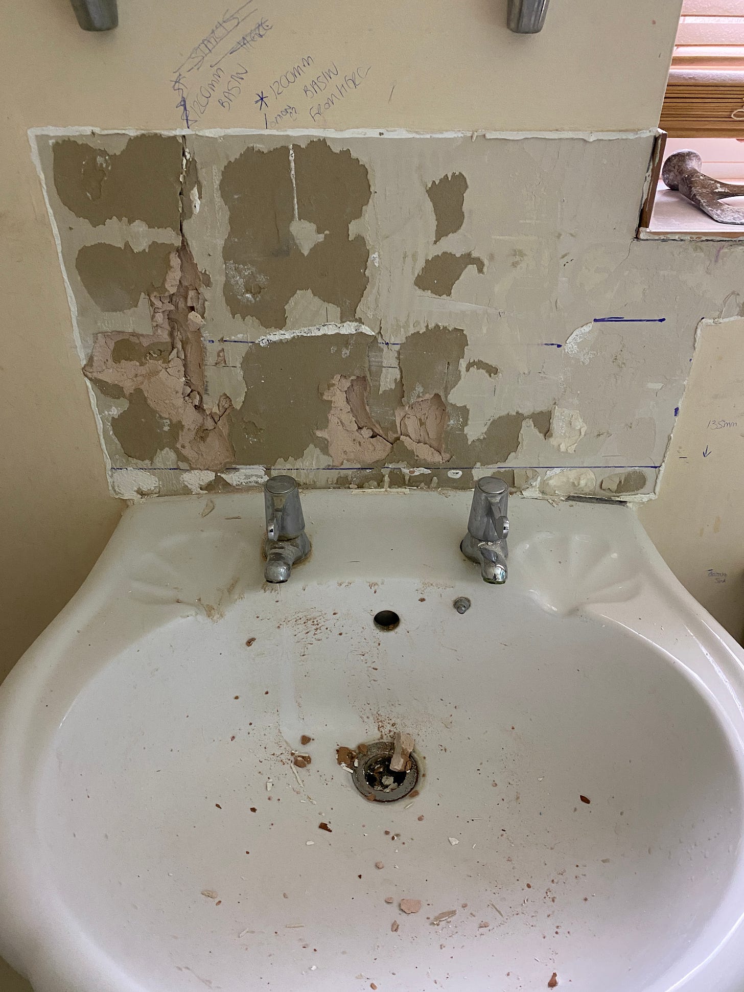 plaster board behind the sink following the tiles being removed