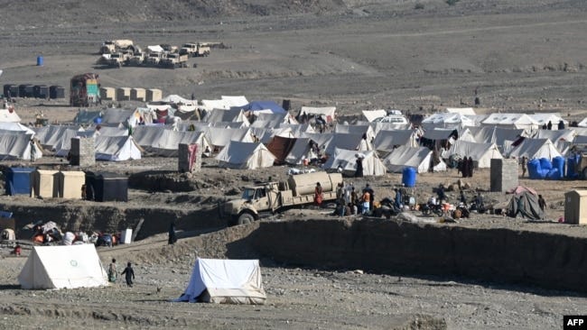 Afghan refugees sit outside their tents at a makeshift camp upon their arrival from Pakistan near the Afghanistan-Pakistan Torkham border in Nangarhar Province on November 12.
