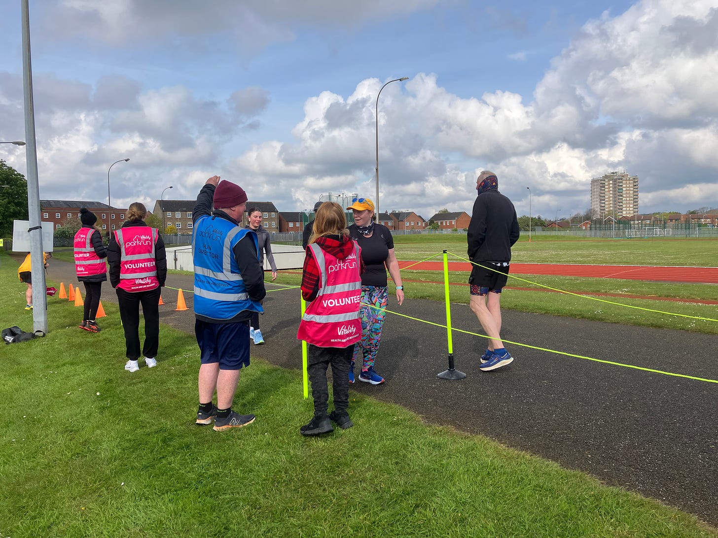 A participant taking her finish token from her son, with the run director watching on