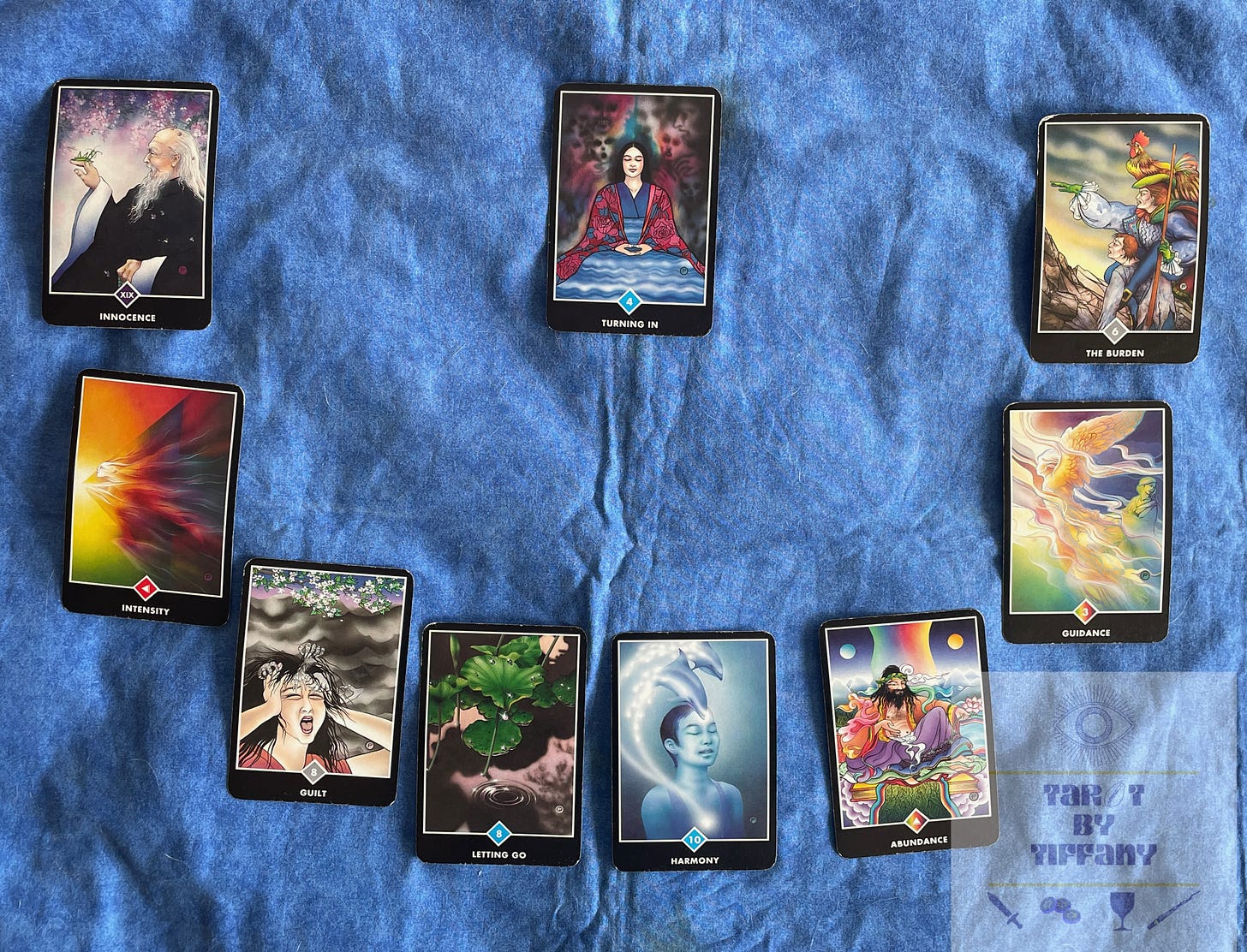 A nine-card layout that resembles a menorah, using the Osho Zen Tarot. There are eight cards making a large U-shape, then the ninth card at the top center of the spread.