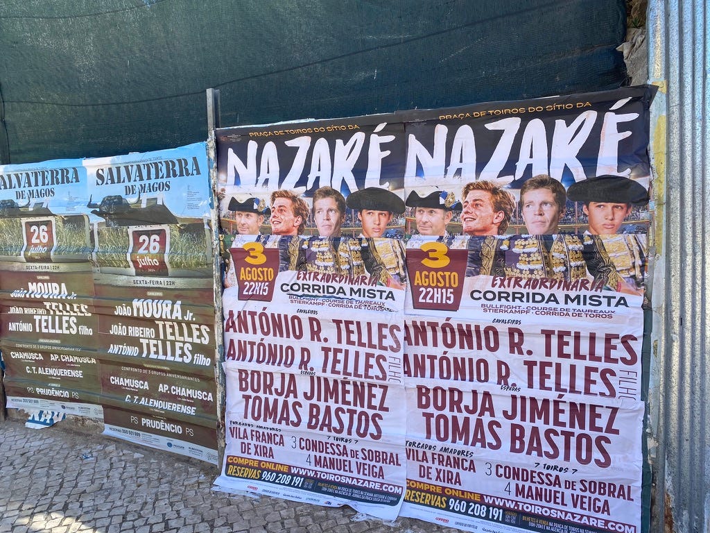 Posters advertising matadors and events in Portugal in a metal fence