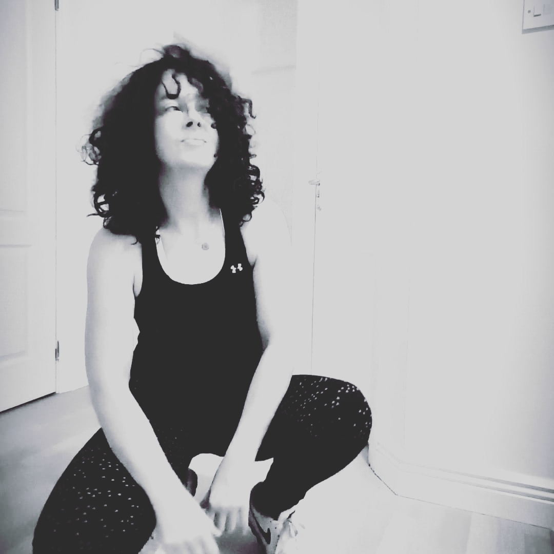 Black and white photo of a woman with curly hair staring at nothing