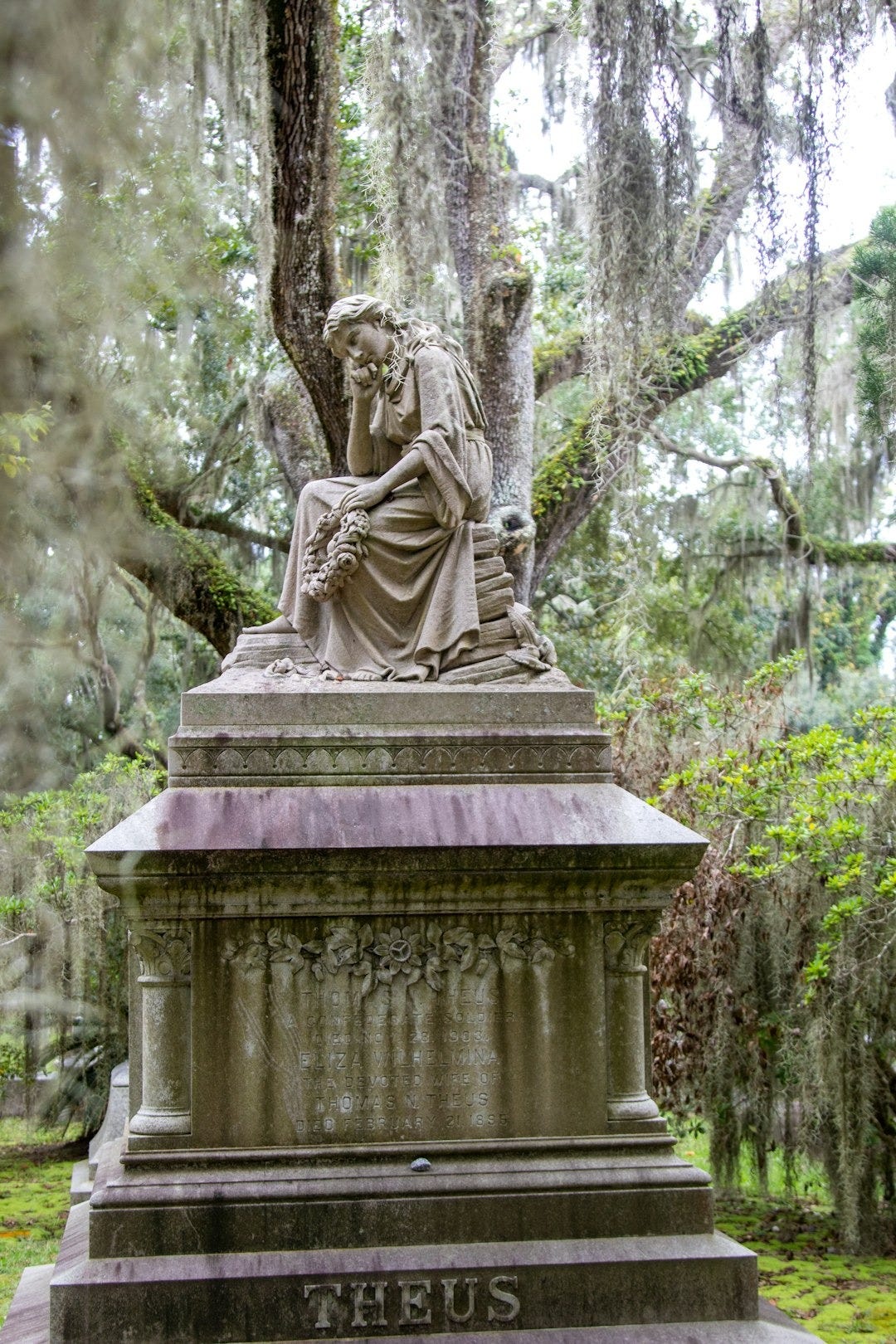 A statue of a woman sitting under a tree A statue of a woman sitting under a tree