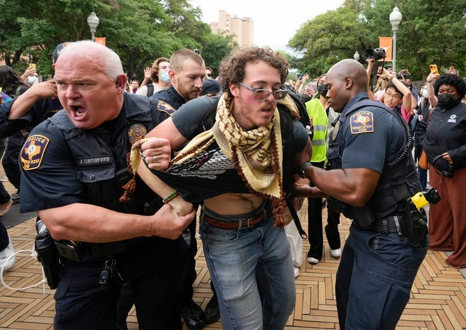 University of Texas police officers arrest a man at Wednesday's pro-Palestinian protest, one of at least 30 arrests made at UT during the protest.