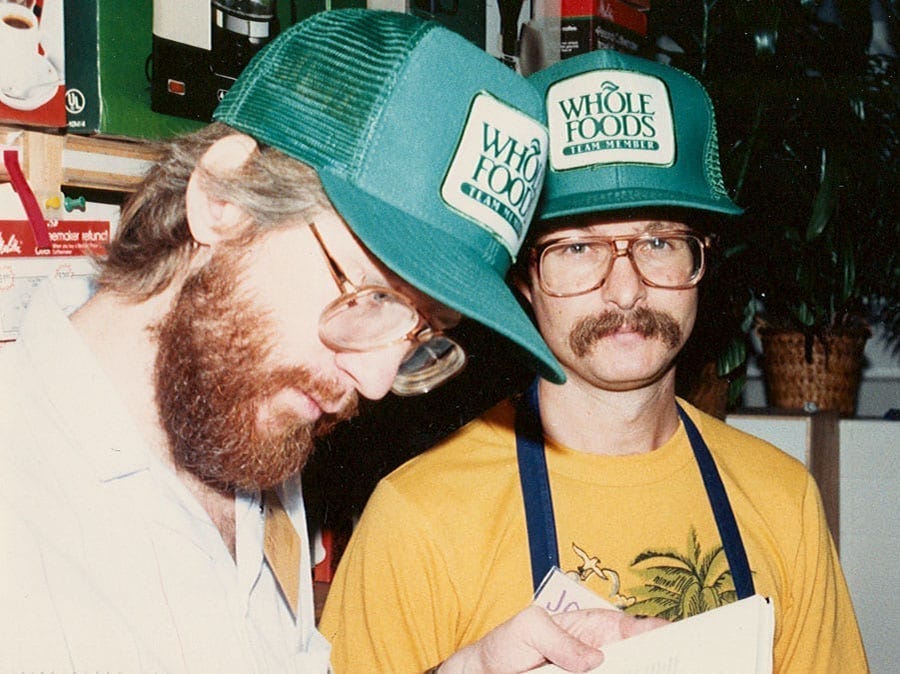 John Mackey, right, with Whole Foods employee David Matthis at the opening of a Houston store in 1984.