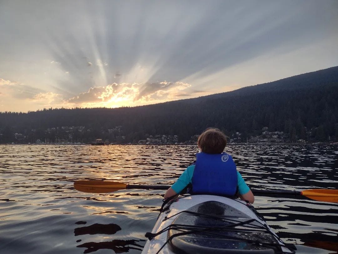 An image of 1 person in a kayak at Deep Cove, BC at sunset. 