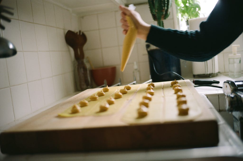 Victoria Bermudez piping squash filling into handmade pasta