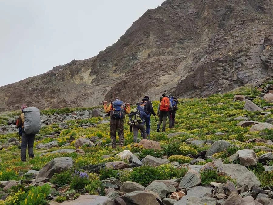 Group of trekkers hiking through rocky terrain on Yunam Peak trek