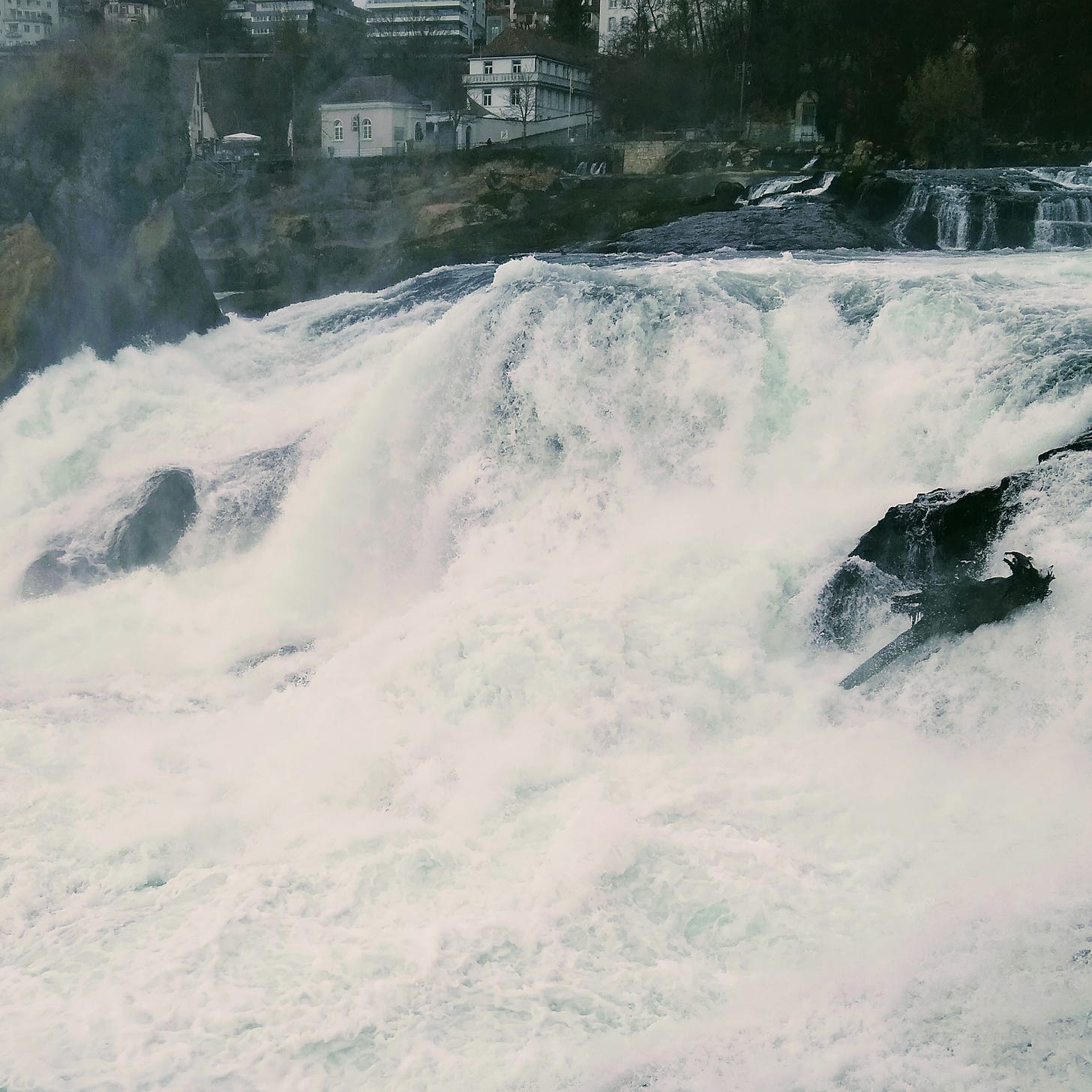 A foaming torrent of water cascades through a small town.