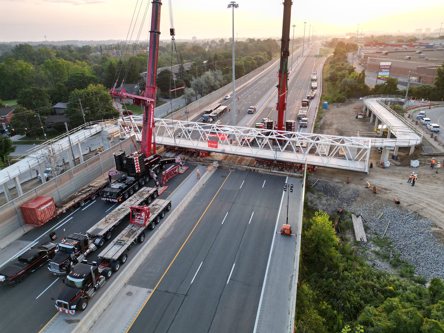 Large vehicles are used to install the pedestrian bridge across highway 7/8