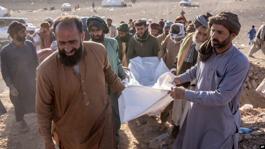Afghans carry the body of a relative killed Oct. 9, 2023, during an earthquake that struck the Zindajan district of the Herat province in Afghanistan.
