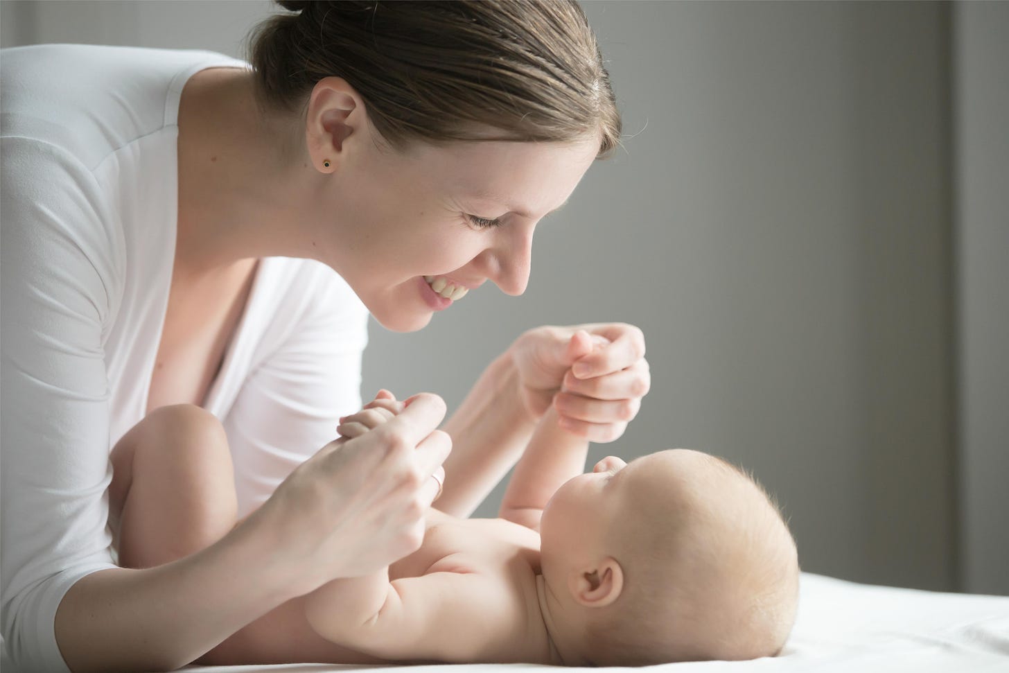 A mother is gently massaging her infant