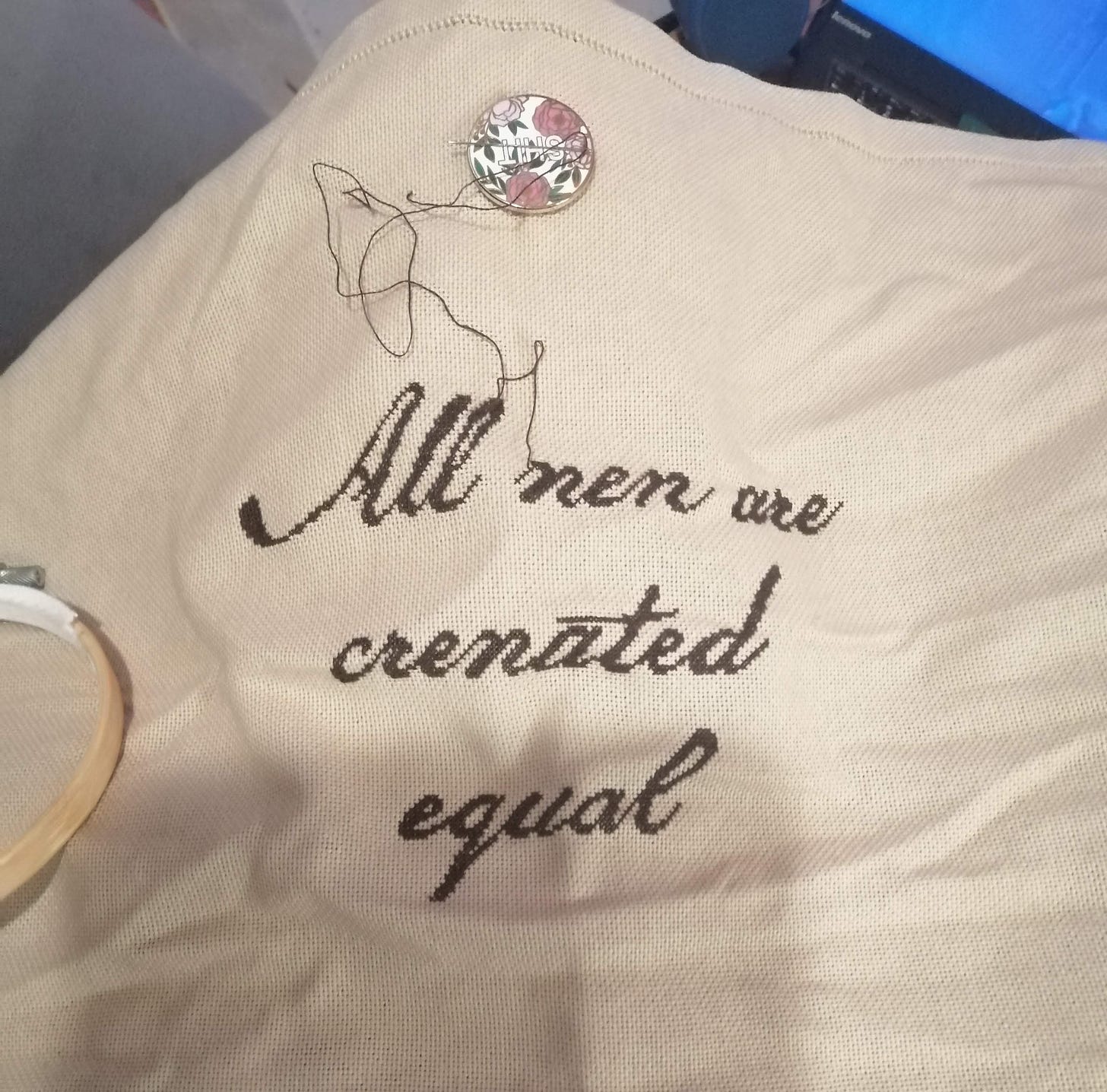 Cross stitch fresh off the hoop. The text reads "All nen are crenated equal"