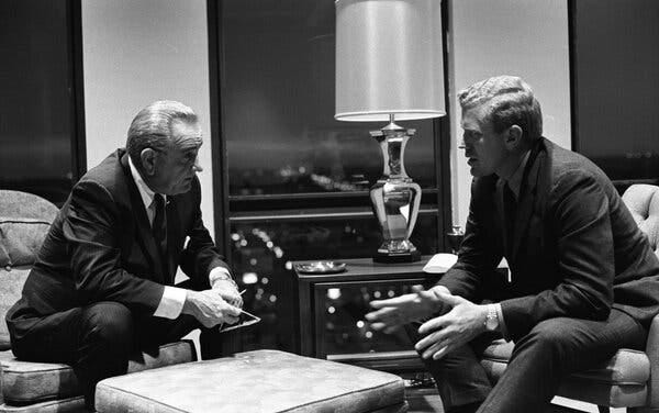 Mr. Barnes sitting and talking with President Lyndon B. Johnson, both wearing suits 
