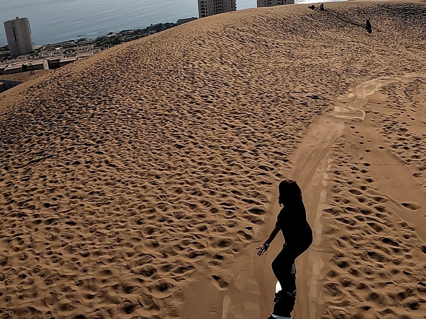 La autora haciendo sandboard en la mayor duna urbana del mundo en Iquique. Foto propia. 