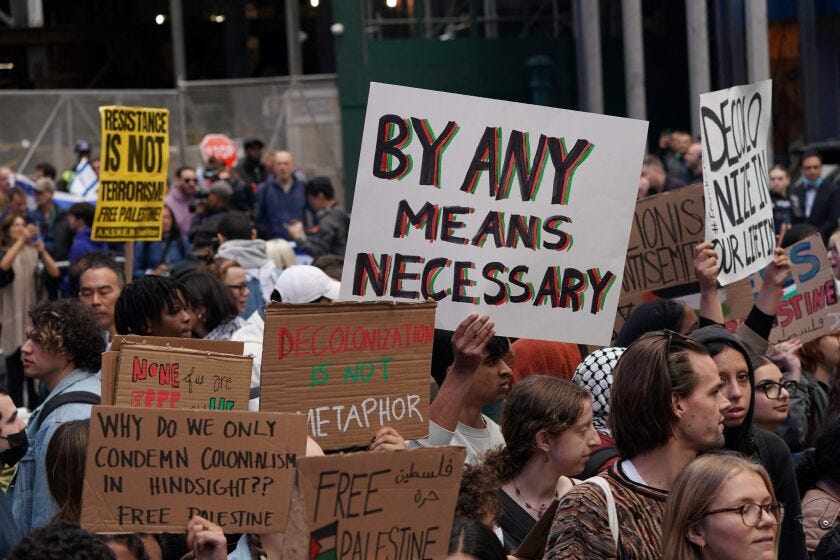 A sign reading “by any means necessary” is displayed at a rally in support of Palestinians in Times Square in New York Oct. 8, the day after Hamas launched an attack on Israel.