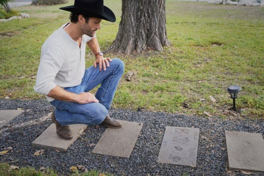 Walker Jared Padalecki looking at family handprints in stones leading to house