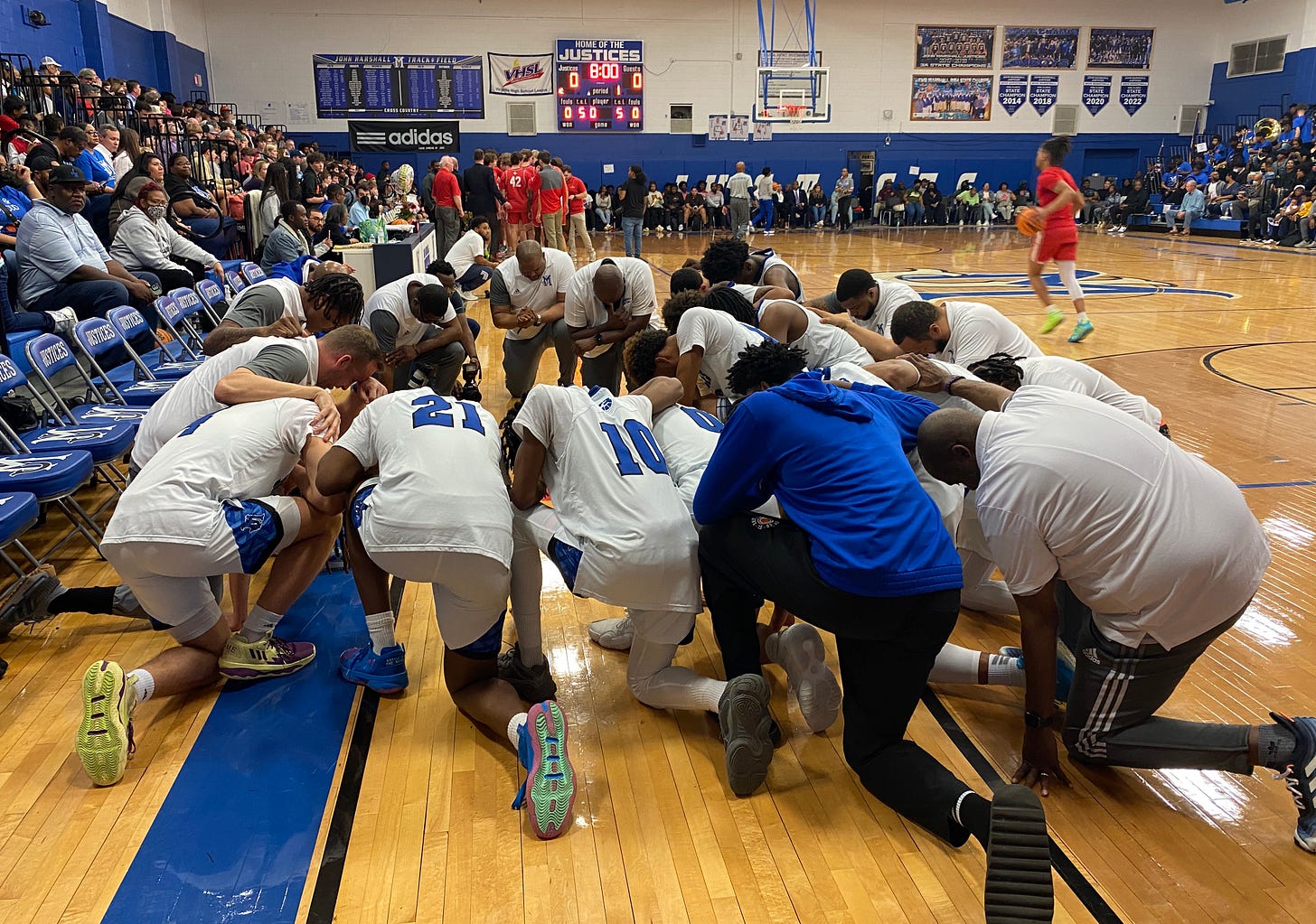 The John Marshall Justices before the game say a prayer