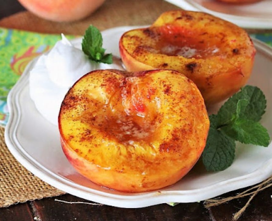 A photograph of two roasted peaches.