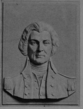 Bas relief of a man with a widow's peak and strong jaw wearing a high collared military jacket. His mouth is straight giving him the appearance of a strong leader. The eyes are looking at the viewer.