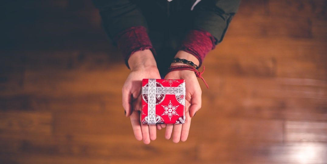 person holding red and white box