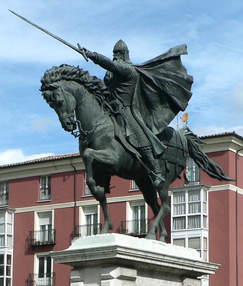 a stature of a knight on a hose, his sword drawn and pointing forward