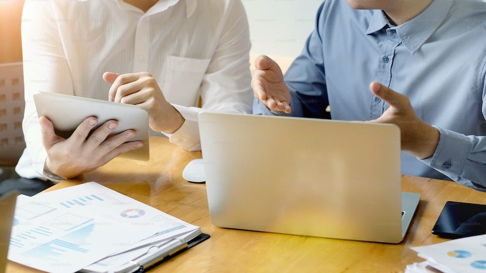 Cropped shot business together consult with digital tablet and computer on office workplace.