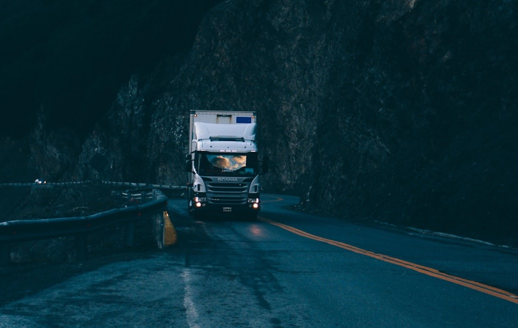 trailer truck passing on road near rail guard