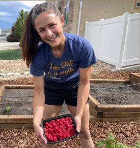 me holding a box of raspberries from my garden