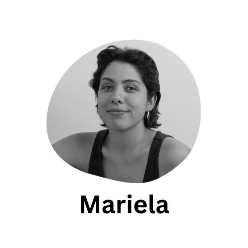 A black-and-white photo of Mariela, a Mexican writer. She is standing against a wall. Mariela has short wavy hair, is wearing small silver earrings and a black sleeveless top. She is smiling at the camera.