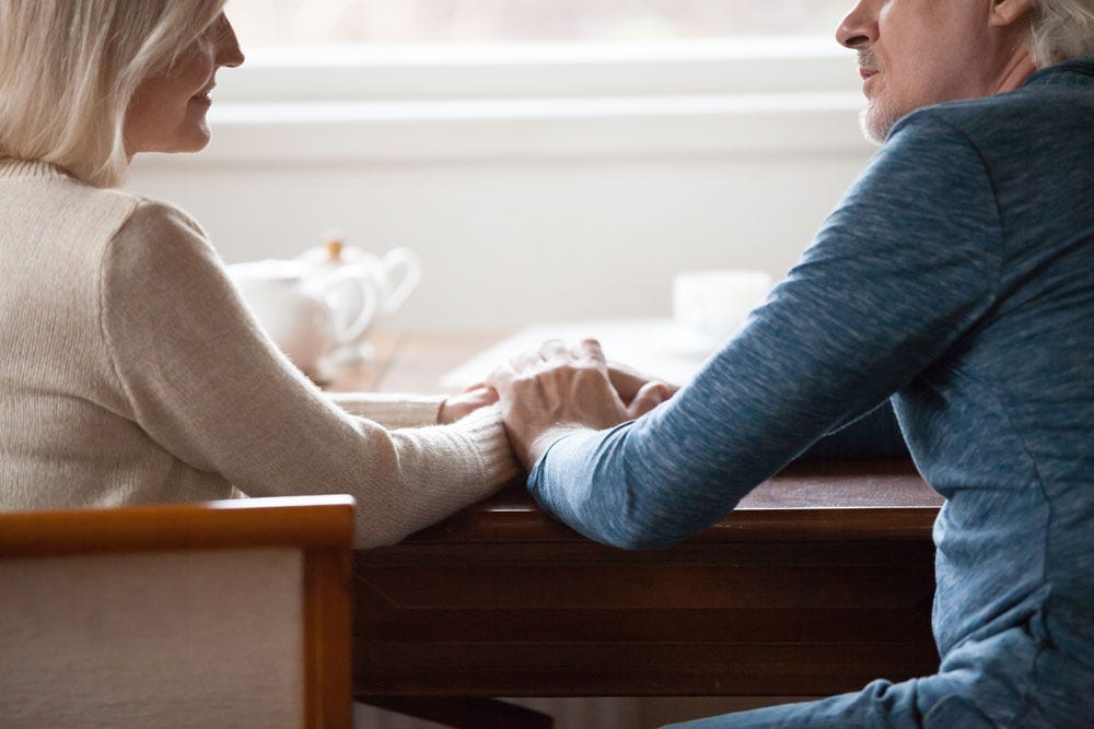 Two people reconciling at a kitchen table.