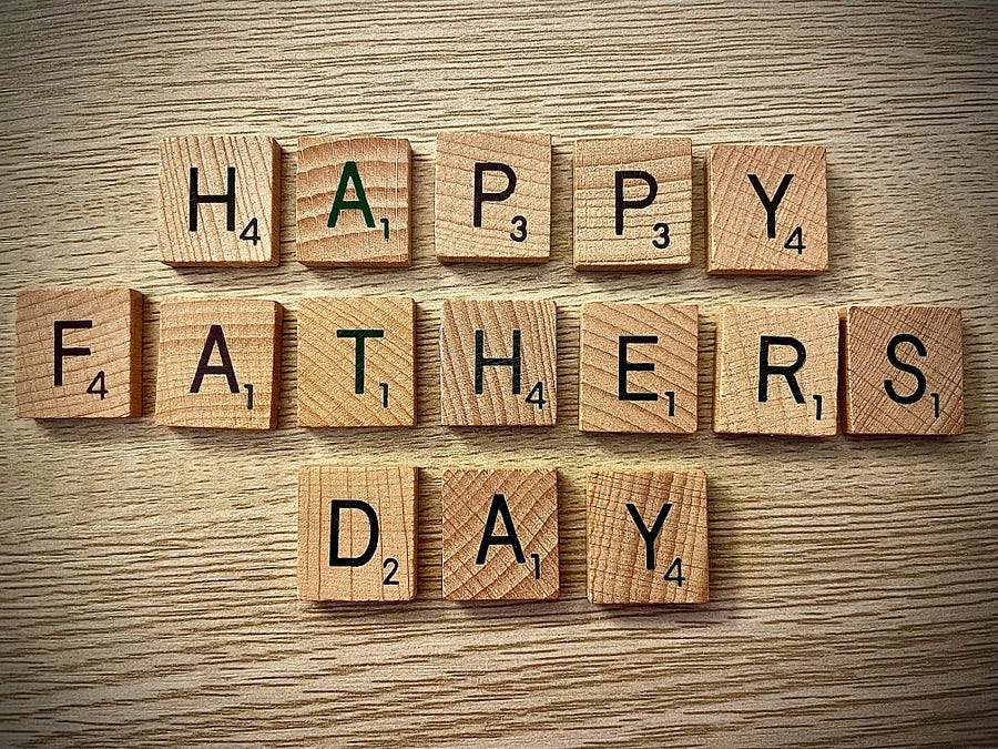 alphabets spell “Happy Fathers Day” on blocks of wood.
