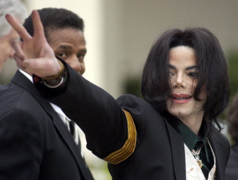 Michael Jackson waves to fans at court during child molestation charges.