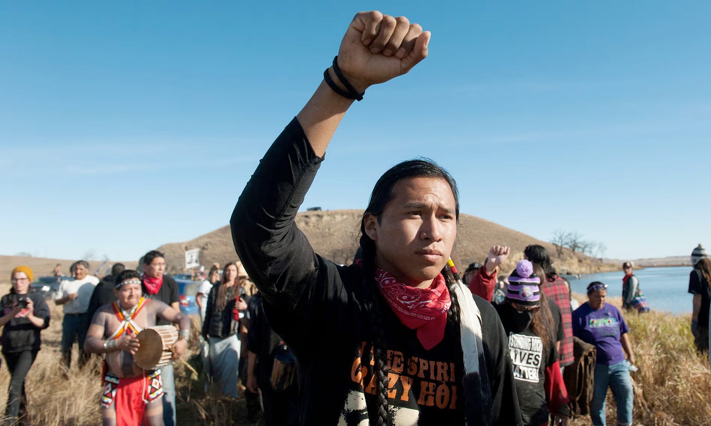 Sioux protestors, young man lightly clenched hand in air in solidarity.